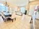 Open-concept living room with dining area, tiled flooring, and natural light from the front door at 4716 98Th E Ter, Parrish, FL 34219