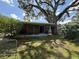 Enclosed back porch overlooking an overgrown backyard with mature trees offering ample shade at 5124 17Th Street E Ct, Bradenton, FL 34203
