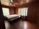 Bedroom with ceiling fan, wood paneling, hardwood floors and natural light from the two windows at 5124 17Th Street E Ct, Bradenton, FL 34203
