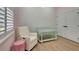 Bedroom featuring a green crib, a rocking chair, and white shutters and closet doors at 5139 50Th W Ave, Bradenton, FL 34210
