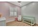 Pink Bedroom featuring a green crib, a rocking chair, white shutters, and light wood floors at 5139 50Th W Ave, Bradenton, FL 34210