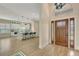 Bright foyer view into the kitchen with a large island, pendant lighting, and wood-look tile flooring at 5139 50Th W Ave, Bradenton, FL 34210