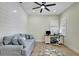Bright home office with a modern ceiling fan, shiplap wall, and a comfortable seating area at 5139 50Th W Ave, Bradenton, FL 34210
