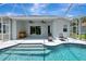 View of a screened in pool with chaise lounges, custom cooler, and view of interior through sliding doors at 5139 50Th W Ave, Bradenton, FL 34210