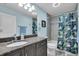 Updated bathroom featuring a granite countertop, framed mirror, and a shower with a tropical shower curtain at 529 Sunset N Rd, Rotonda West, FL 33947