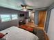 Bright bedroom featuring neutral decor, a ceiling fan, mounted television, and hardwood floors at 5316 Chateau Ln, Bradenton, FL 34207