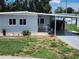 Charming single-story home featuring light-grey siding, a covered carport, and a cozy front porch at 5316 Chateau Ln, Bradenton, FL 34207