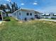 Light blue single story home with a well-kept lawn and a carport under a blue sky at 5316 Chateau Ln, Bradenton, FL 34207