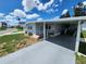 Single-story home with light-grey siding, covered parking, a cozy porch, and a well-manicured lawn at 5316 Chateau Ln, Bradenton, FL 34207