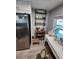 Bright kitchen area with decorative shelves, stainless steel refrigerator, and eclectic decor at 5316 Chateau Ln, Bradenton, FL 34207