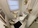 Cozy toilet area showcasing framed art, a window, toilet, and decorative storage baskets at 5316 Chateau Ln, Bradenton, FL 34207