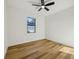 A sunlit bedroom with modern ceiling fan, window, and light wood floors at 5386 Easter Ter, North Port, FL 34286