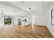 Open-concept living room with hardwood floors and views of the modern white kitchen at 5386 Easter Ter, North Port, FL 34286