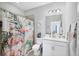 Bright bathroom includes a flamingo shower curtain, single vanity, and tile flooring at 5981 Amberly Dr, Bradenton, FL 34208