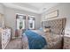 Comfortable bedroom boasts a tufted headboard, soft lighting, and natural light from two windows at 5981 Amberly Dr, Bradenton, FL 34208