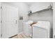 This laundry room offers a washer, a dryer, tile flooring, and shelving at 5981 Amberly Dr, Bradenton, FL 34208