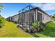 Back exterior view of a home with a screened-in lanai and landscaped backyard at 5981 Amberly Dr, Bradenton, FL 34208