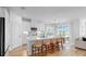 Modern white kitchen with island seating, stainless steel appliances, and adjacent dining area at 6120 115Th E Ave, Parrish, FL 34219