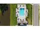 Aerial view of the pool area with blue pool, lounge chairs, palm trees, and cabana overlooking a pond at 6120 115Th E Ave, Parrish, FL 34219