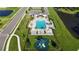 This aerial view showcases a beautiful blue pool, cabana and playground near lush green grass and a pond at 6120 115Th E Ave, Parrish, FL 34219