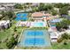 Aerial view of community amenities including tennis courts, pool, and clubhouse with lush landscaping at 618 Bird Bay S Dr # 113, Venice, FL 34285