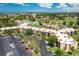 An aerial view of buildings surrounded by lush greenery, parking lots, and neighborhood at 618 Bird Bay S Dr # 113, Venice, FL 34285