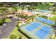 Overhead view of tennis courts, a pool, and other amenities, surrounded by lush landscaping at 618 Bird Bay S Dr # 113, Venice, FL 34285