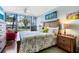 Bedroom features a tropical view, ceiling fan, and comfortable bed with decorative pillows at 618 Bird Bay S Dr # 113, Venice, FL 34285
