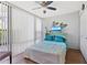 Bright bedroom with a large window, ceiling fan, and comfortable bed with decorative pillows at 618 Bird Bay S Dr # 113, Venice, FL 34285