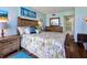 Bedroom with a queen bed, ceiling fan, painting and view into the bathroom at 618 Bird Bay S Dr # 113, Venice, FL 34285