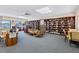Inviting library space with extensive bookshelves, comfortable seating, and natural light at 618 Bird Bay S Dr # 113, Venice, FL 34285