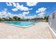 Outdoor community pool with brick paver deck and plenty of seating on a sunny day at 618 Bird Bay S Dr # 113, Venice, FL 34285