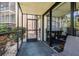 Cozy screened porch with comfortable seating and views of vibrant garden and adjacent building at 618 Bird Bay S Dr # 113, Venice, FL 34285