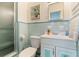 Bathroom with blue and white tiles, a shower with glass doors, and a white vanity at 6180 42Nd N Ave, St Petersburg, FL 33709