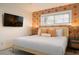 Bright bedroom featuring wallpaper, white linens, and a flat screen television at 6180 42Nd N Ave, St Petersburg, FL 33709