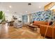 A stylish living room featuring modern furniture, a colorful wallpaper, and wood-look floors at 6180 42Nd N Ave, St Petersburg, FL 33709