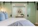 Stylishly decorated main bedroom with a large bed and an ensuite bathroom behind sliding barn doors at 6180 42Nd N Ave, St Petersburg, FL 33709