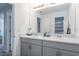 Well-lit bathroom featuring double sinks, gray cabinets, and a large mirror at 6256 Springmont Loop, Palmetto, FL 34221