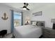 Bedroom with a gray bed, neutral walls, ceiling fan, and blue curtains at 6256 Springmont Loop, Palmetto, FL 34221