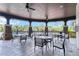 Covered outdoor seating area with tables and chairs near the pool at 6256 Springmont Loop, Palmetto, FL 34221
