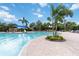 Resort-style community pool with sun loungers, shady areas, and beautiful landscaping at 6256 Springmont Loop, Palmetto, FL 34221