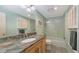 Bright bathroom with a stone countertop, walk-in shower, and storage cabinets at 626 46Th St, Sarasota, FL 34234
