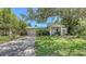 Inviting single-story home with a lush front yard, mature trees, and a cozy, covered front porch at 626 46Th St, Sarasota, FL 34234
