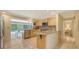 Bright kitchen with modern appliances, light wood cabinetry, and a view of the pool area at 626 46Th St, Sarasota, FL 34234