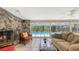 Sun-filled living area with a stone fireplace and sliding glass doors with views of a screened pool at 626 46Th St, Sarasota, FL 34234