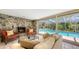 Living room with stone fireplace, comfortable seating, and screened pool view through large sliding doors at 626 46Th St, Sarasota, FL 34234
