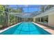 Large screened-in pool surrounded by lush greenery, creating a private oasis at 626 46Th St, Sarasota, FL 34234