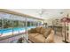 Bright sunroom with a sofa and exercise equipment overlooking the screened in pool and backyard at 626 46Th St, Sarasota, FL 34234
