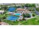 Aerial view of community center with pool, tennis courts, and lush landscaping at 718 White Pine Tree Rd # 80, Venice, FL 34285