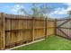 Enclosed backyard featuring an artificial turf lawn and a wooden fence at 718 White Pine Tree Rd # 80, Venice, FL 34285